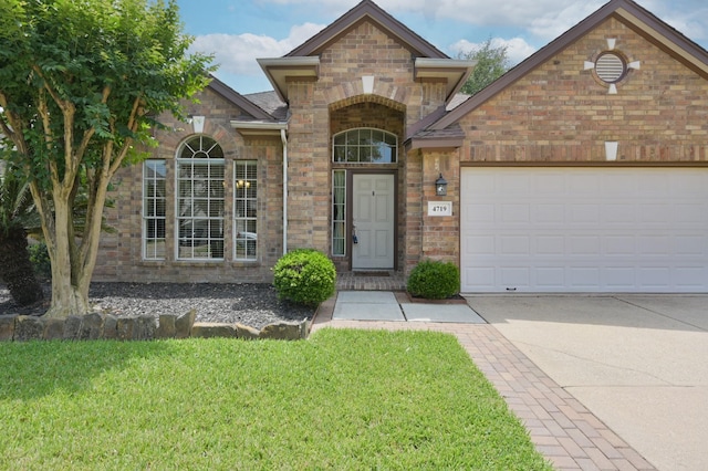 4719 Meadows Edge Ln, Houston, TX 77084 - view of front of property featuring a front lawn, driveway, an attached garage, and brick siding