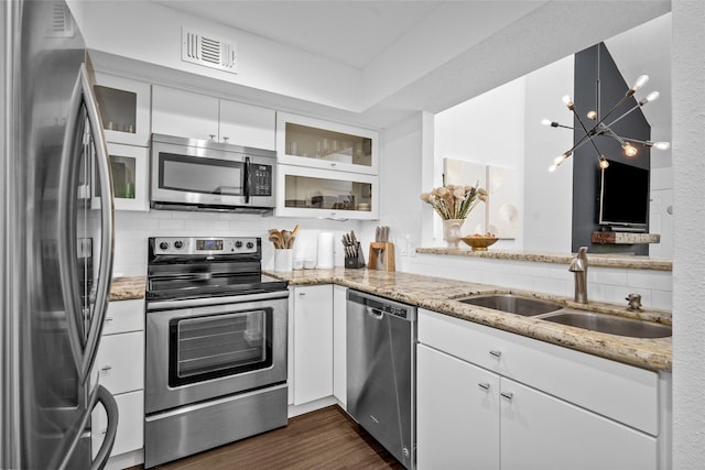 kitchen featuring visible vents, a sink, backsplash, white cabinets, and appliances with stainless steel finishes