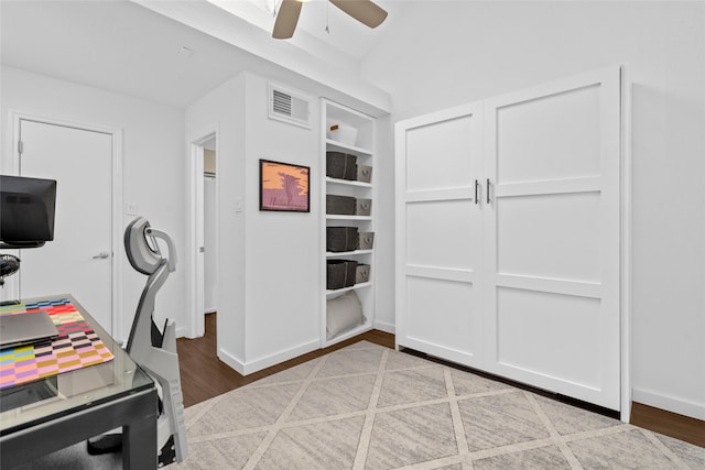 office space with a ceiling fan, baseboards, visible vents, and wood finished floors