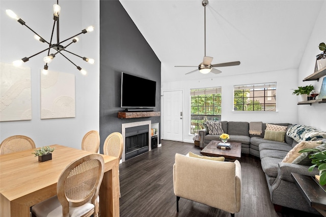 living area featuring a fireplace, ceiling fan with notable chandelier, dark wood-type flooring, and high vaulted ceiling