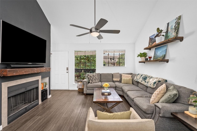 living area featuring lofted ceiling, a fireplace, ceiling fan, and dark wood-style floors