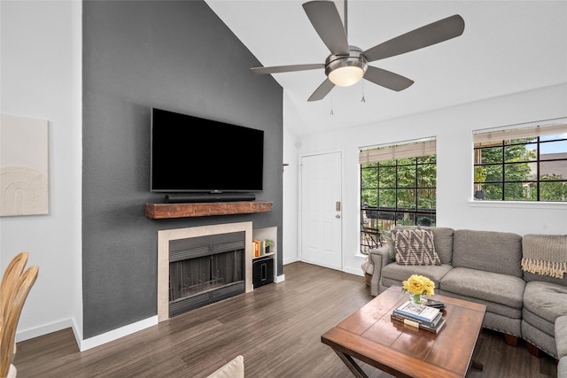 living area featuring baseboards, wood finished floors, a fireplace, and ceiling fan