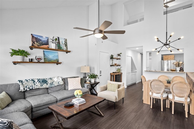 living room with ceiling fan with notable chandelier, high vaulted ceiling, and wood finished floors