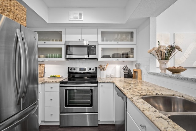 kitchen featuring a sink, white cabinets, visible vents, backsplash, and appliances with stainless steel finishes
