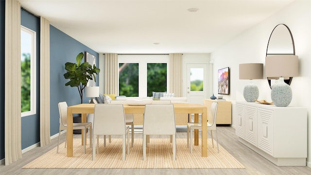dining space with baseboards and light wood-style flooring