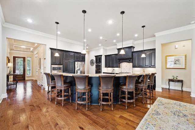 19907 Cullen Ridge Dr, Porter, TX 77365 - kitchen featuring a kitchen breakfast bar, tasteful backsplash, stainless steel appliances, ornamental molding, and wood finished floors