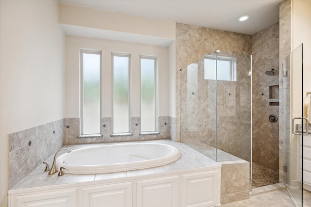 bathroom with a shower stall and a garden tub