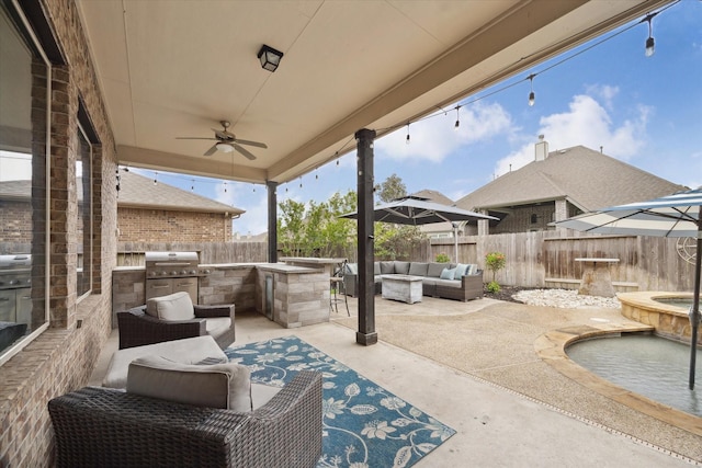 view of patio featuring outdoor lounge area, a fenced backyard, a ceiling fan, and exterior kitchen