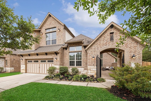 view of front of property with a front yard, driveway, a garage, and brick siding