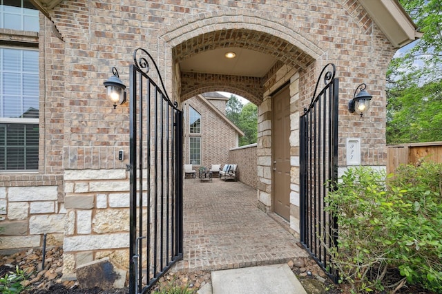 property entrance with a gate and brick siding