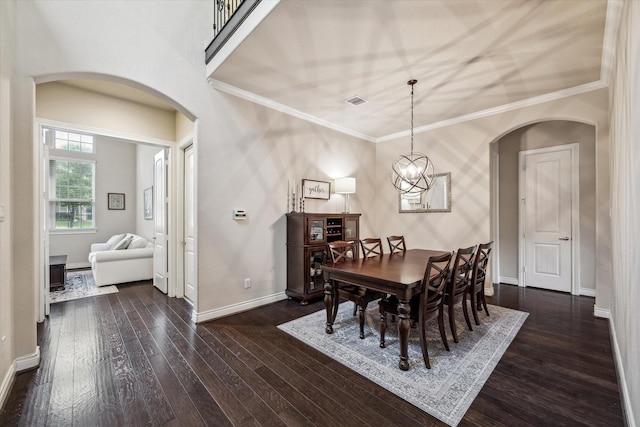 dining room featuring baseboards, arched walkways, dark wood-style flooring, and ornamental molding