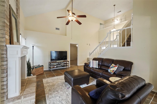 tiled living room featuring visible vents, a ceiling fan, stairs, and high vaulted ceiling