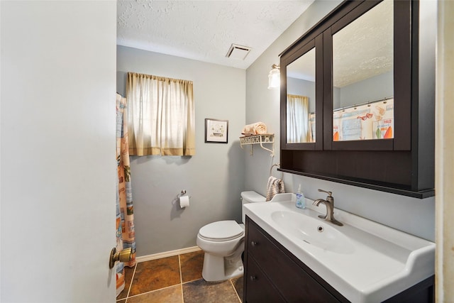 full bath with a textured ceiling, visible vents, vanity, baseboards, and toilet