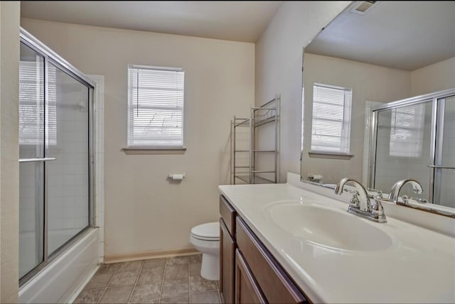 215 N Howard St, Tomball, TX 77375 - full bath featuring vanity, toilet, shower / bath combination with glass door, tile patterned flooring, and baseboards