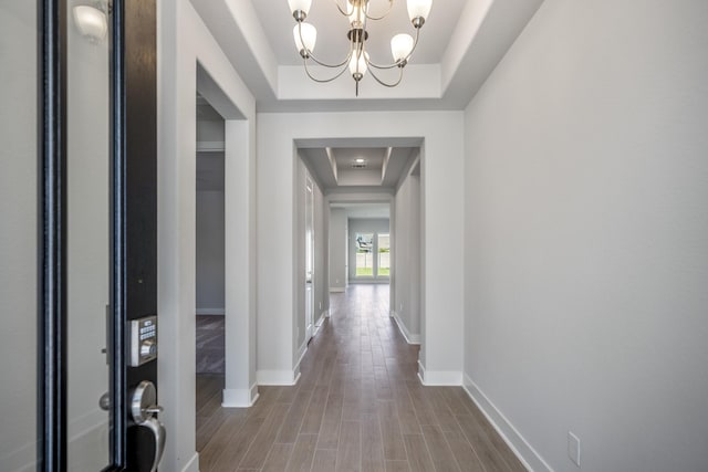 17311 Sunflower Petals Trl, Conroe, TX 77302 - hall with baseboards, a raised ceiling, a notable chandelier, and wood finished floors