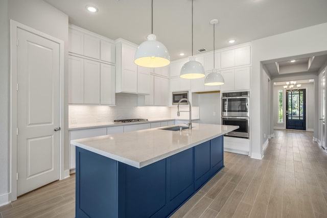 17311 Sunflower Petals Trl, Conroe, TX 77302 - kitchen featuring a chandelier, appliances with stainless steel finishes, a sink, white cabinetry, and light wood-type flooring