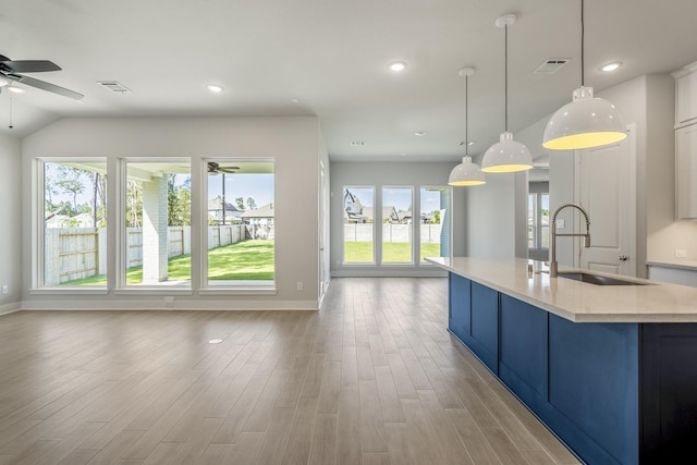 17311 Sunflower Petals Trl, Conroe, TX 77302 - kitchen featuring a sink, a wealth of natural light, a ceiling fan, blue cabinets, and open floor plan