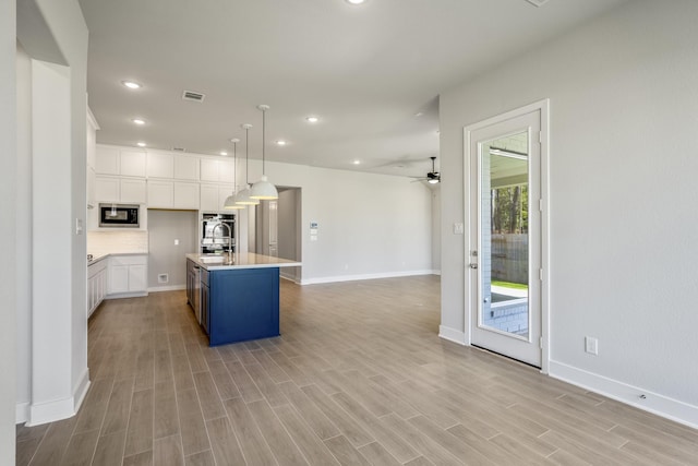 17311 Sunflower Petals Trl, Conroe, TX 77302 - kitchen featuring visible vents, ceiling fan, light countertops, built in microwave, and open floor plan