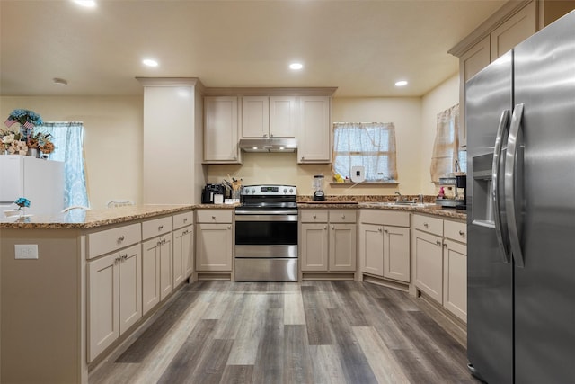 736 County Road 478, Lott, TX 76656 - kitchen featuring appliances with stainless steel finishes, a sink, light stone counters, a peninsula, and under cabinet range hood