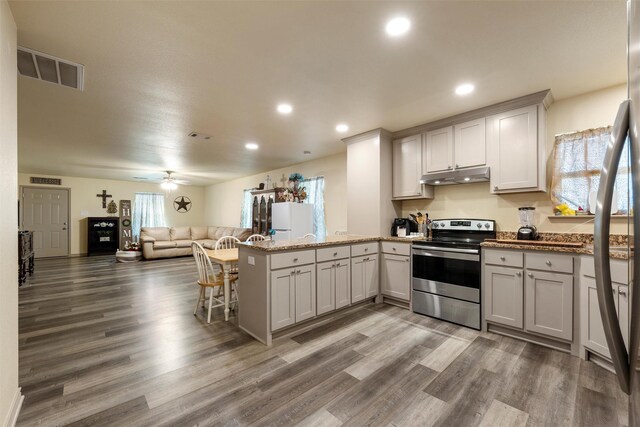 736 County Road 478, Lott, TX 76656 - kitchen featuring visible vents, a peninsula, open floor plan, stainless steel electric range, and under cabinet range hood