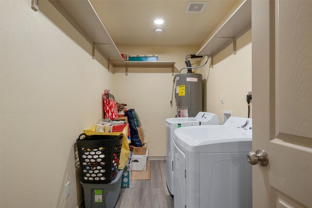 736 County Road 478, Lott, TX 76656 - clothes washing area featuring laundry area, visible vents, washing machine and clothes dryer, light wood-type flooring, and electric water heater
