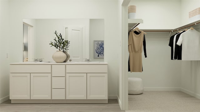 full bath featuring baseboards, double vanity, and a sink