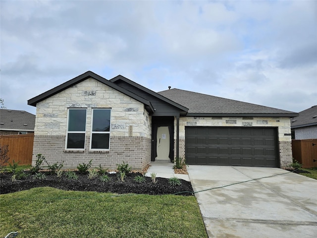 view of front of home with a garage, fence, driveway, and a front yard