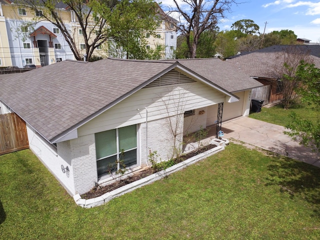 view of front of home with fence, a front lawn, driveway, and roof with shingles