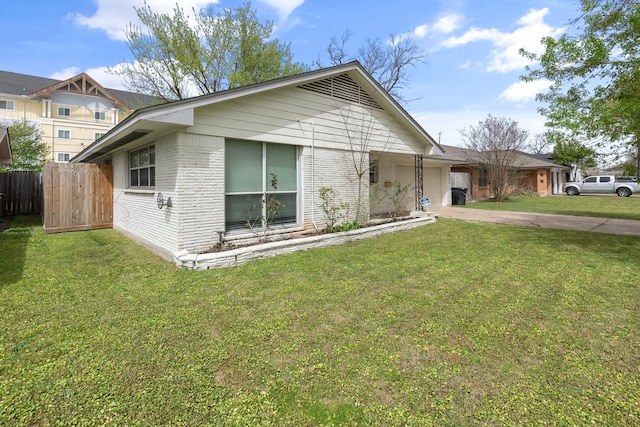 view of front of home with a front lawn, brick siding, concrete driveway, an attached garage, and fence