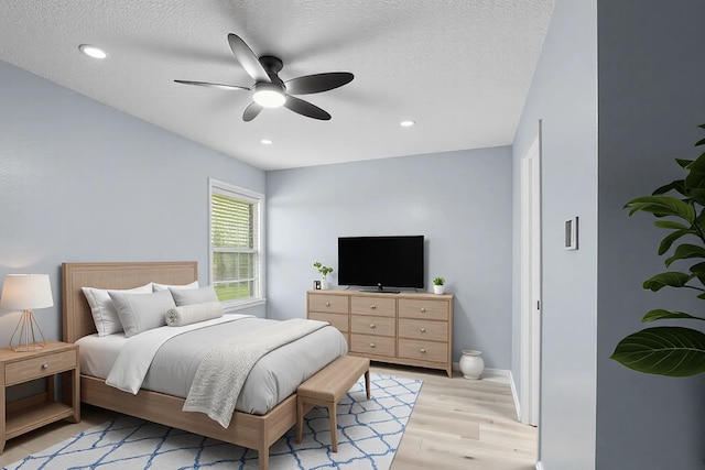 bedroom featuring recessed lighting, a textured ceiling, ceiling fan, and light wood-style flooring