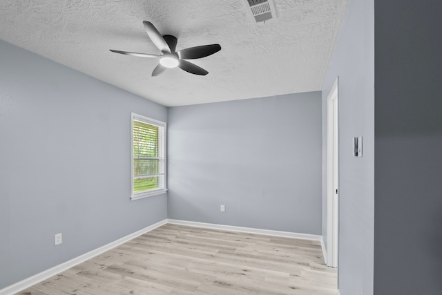 spare room featuring a textured ceiling, wood finished floors, ceiling fan, and visible vents