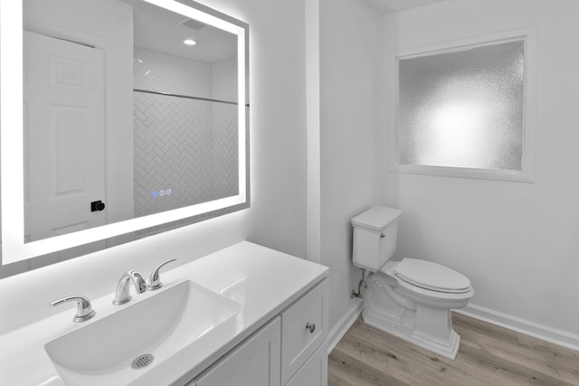 full bathroom with vanity, toilet, a shower, baseboards, and wood finished floors
