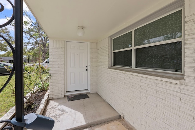 view of exterior entry featuring brick siding