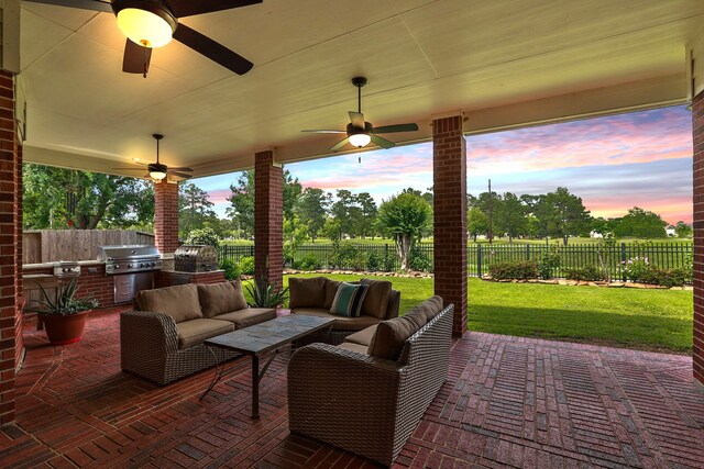 view of patio featuring a fenced backyard, a ceiling fan, exterior kitchen, and area for grilling