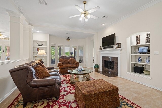 living area with crown molding, a ceiling fan, built in shelves, and plenty of natural light
