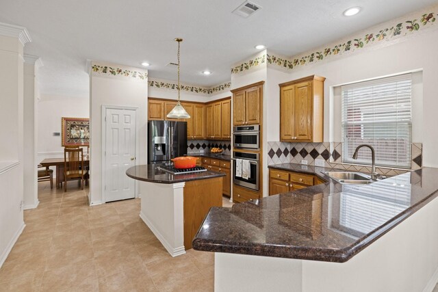 kitchen featuring a sink, a center island, tasteful backsplash, refrigerator with ice dispenser, and visible vents