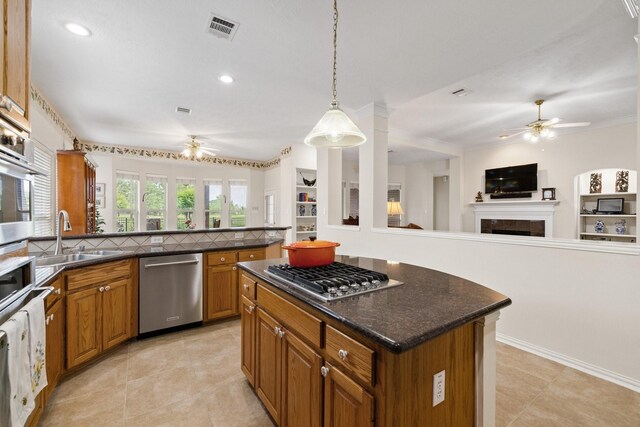 kitchen featuring a sink, ceiling fan, open floor plan, and stainless steel appliances
