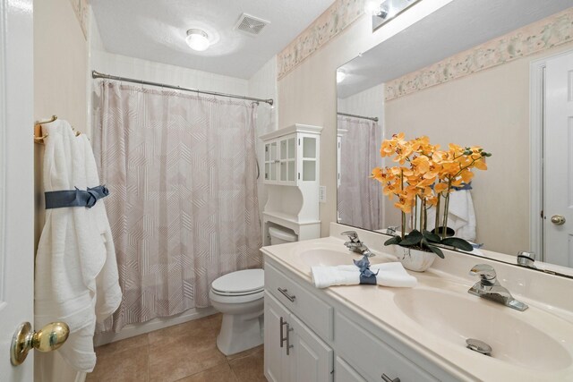 full bathroom featuring toilet, visible vents, a sink, and tile patterned flooring