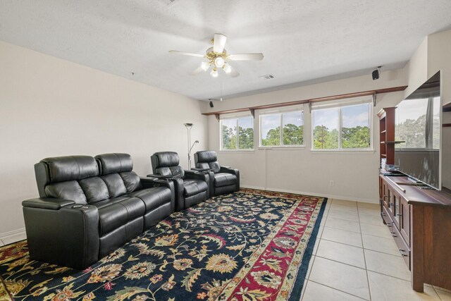 interior space featuring a ceiling fan, a textured ceiling, visible vents, light tile patterned floors, and baseboards