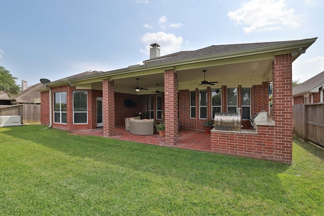 rear view of property featuring a fenced backyard, a chimney, brick siding, a ceiling fan, and a yard