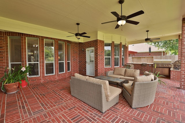 view of patio with ceiling fan, an outdoor living space, exterior kitchen, fence, and a grill