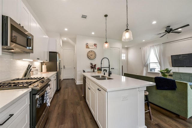 kitchen with stainless steel appliances, recessed lighting, a sink, and dark wood finished floors