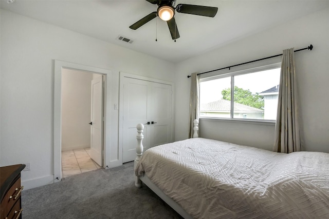 carpeted bedroom featuring visible vents, ceiling fan, and a closet