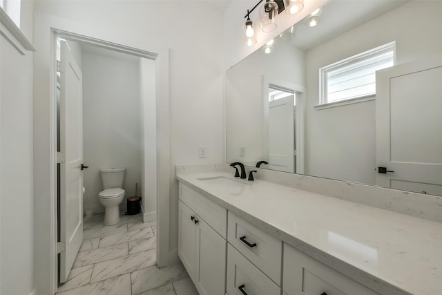 bathroom with vanity, marble finish floor, and toilet