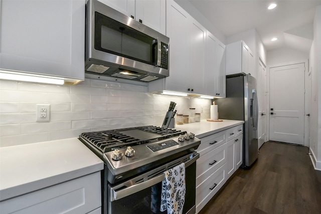 kitchen with light countertops, appliances with stainless steel finishes, backsplash, and dark wood-style floors