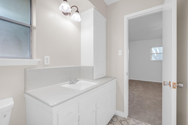 half bathroom featuring baseboards, toilet, and vanity