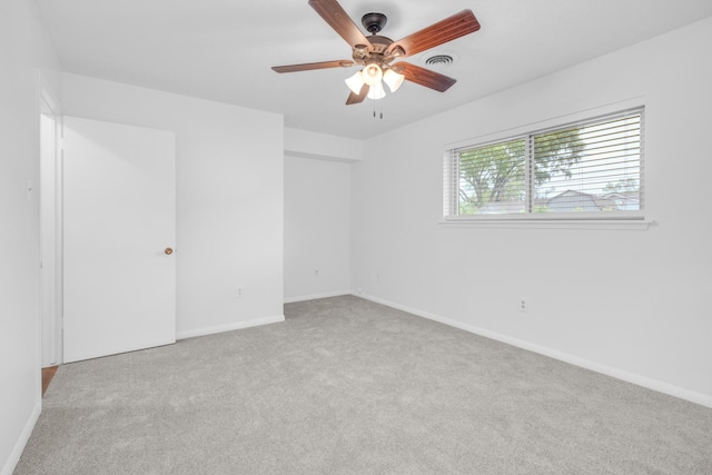 carpeted empty room with visible vents, ceiling fan, and baseboards