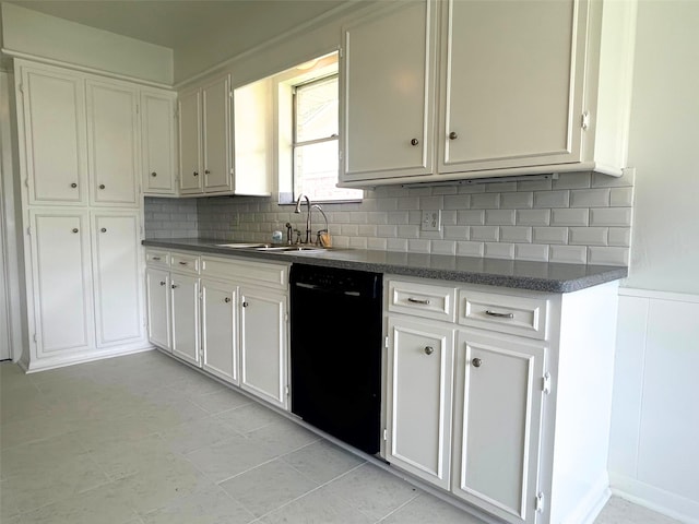 kitchen featuring black dishwasher, a sink, white cabinetry, and decorative backsplash