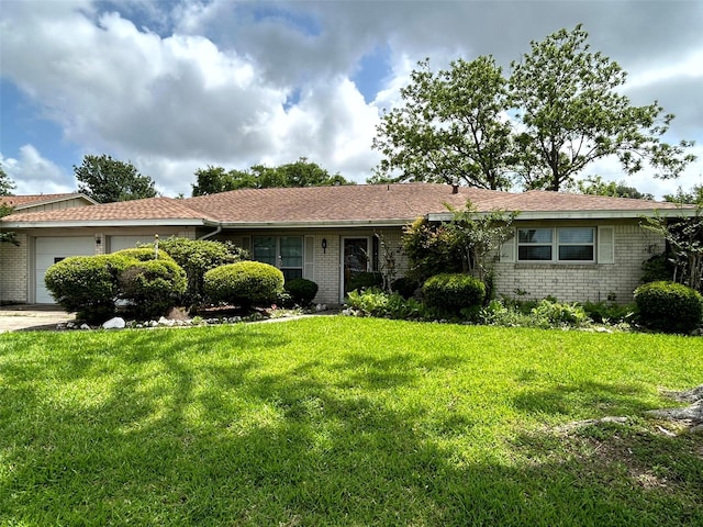 ranch-style home with a garage, brick siding, a front lawn, and driveway