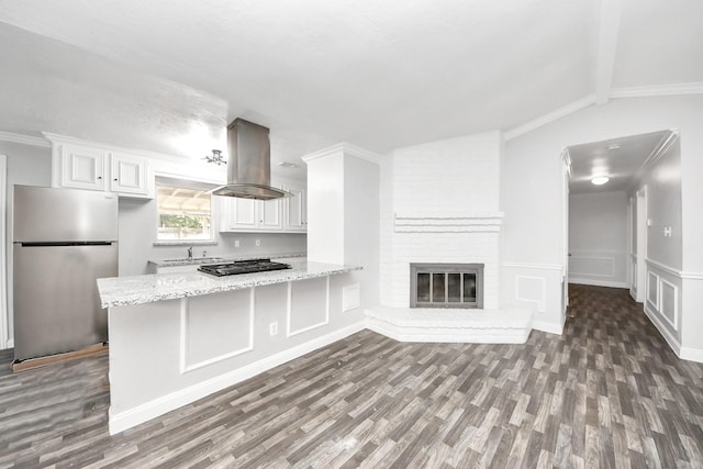 15030 Royal Shadows Dr, Houston, TX 77082 - kitchen with dark wood-style flooring, white cabinets, black gas cooktop, island range hood, and freestanding refrigerator
